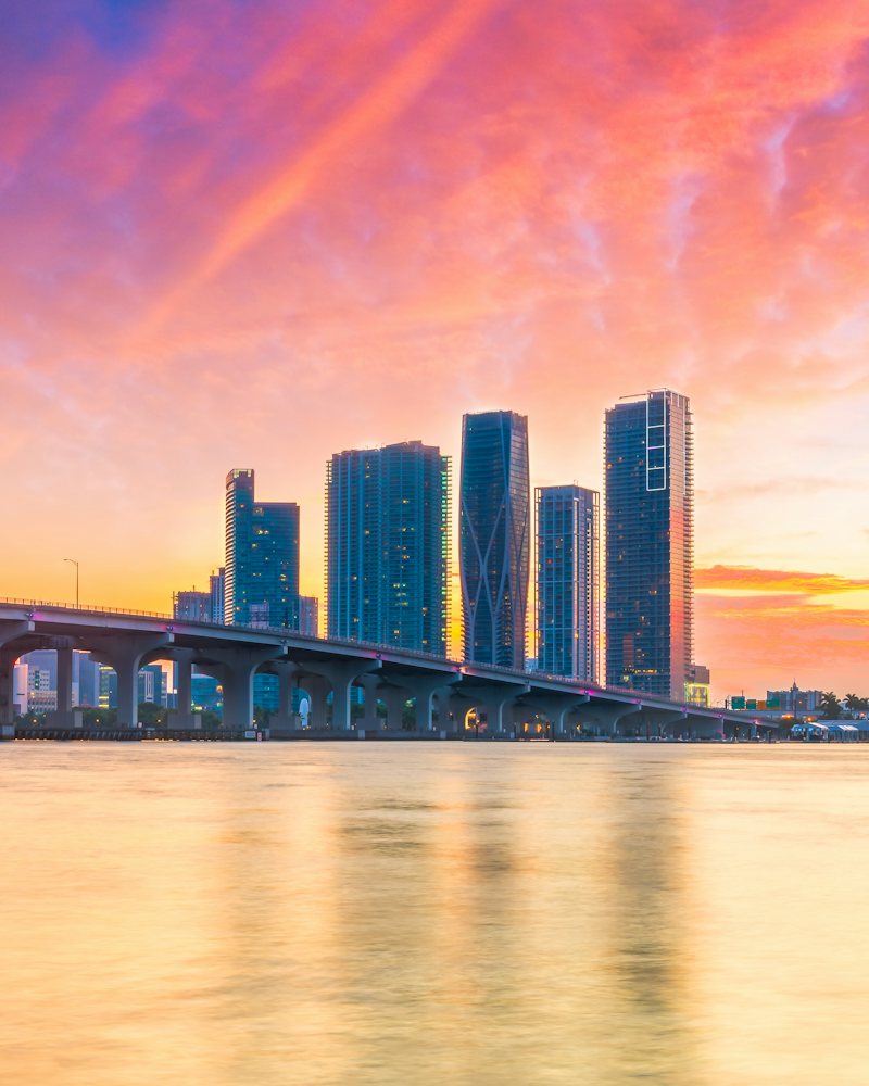 Miami skyline and causeway bridge at sunset over Biscayne Bay