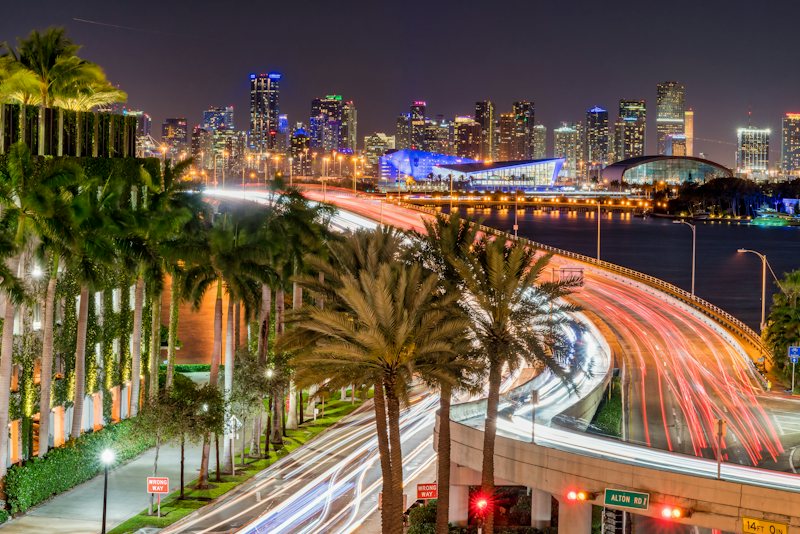 Downtown Miami highways, palm trees and towers at night